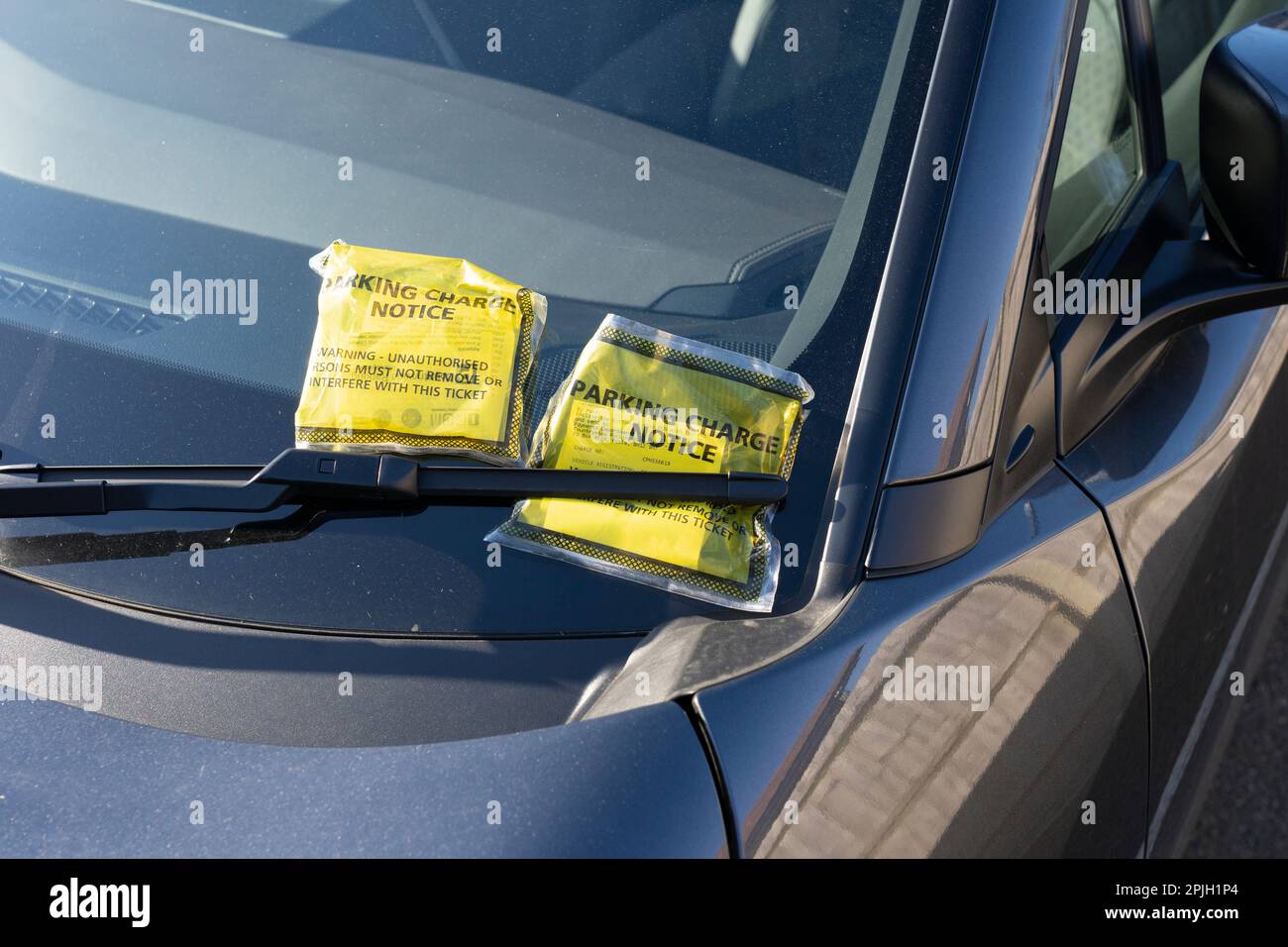 Notice to driver parking charge notice (PCN) tickets on a car windscreen in England. Concept: unfair parking charges, appealing parking fine Stock Photo