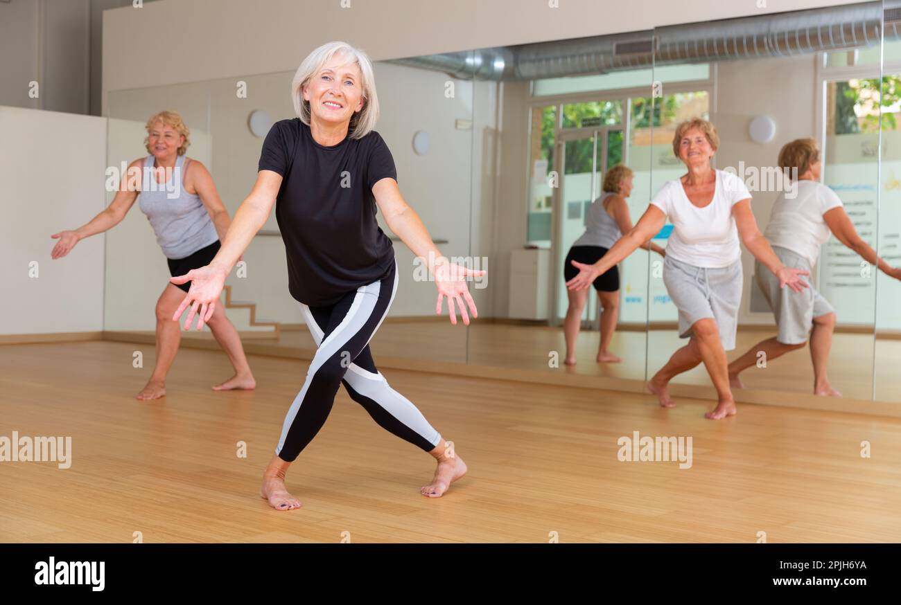 Active mature woman learning dynamic dances in choreography class Stock Photo