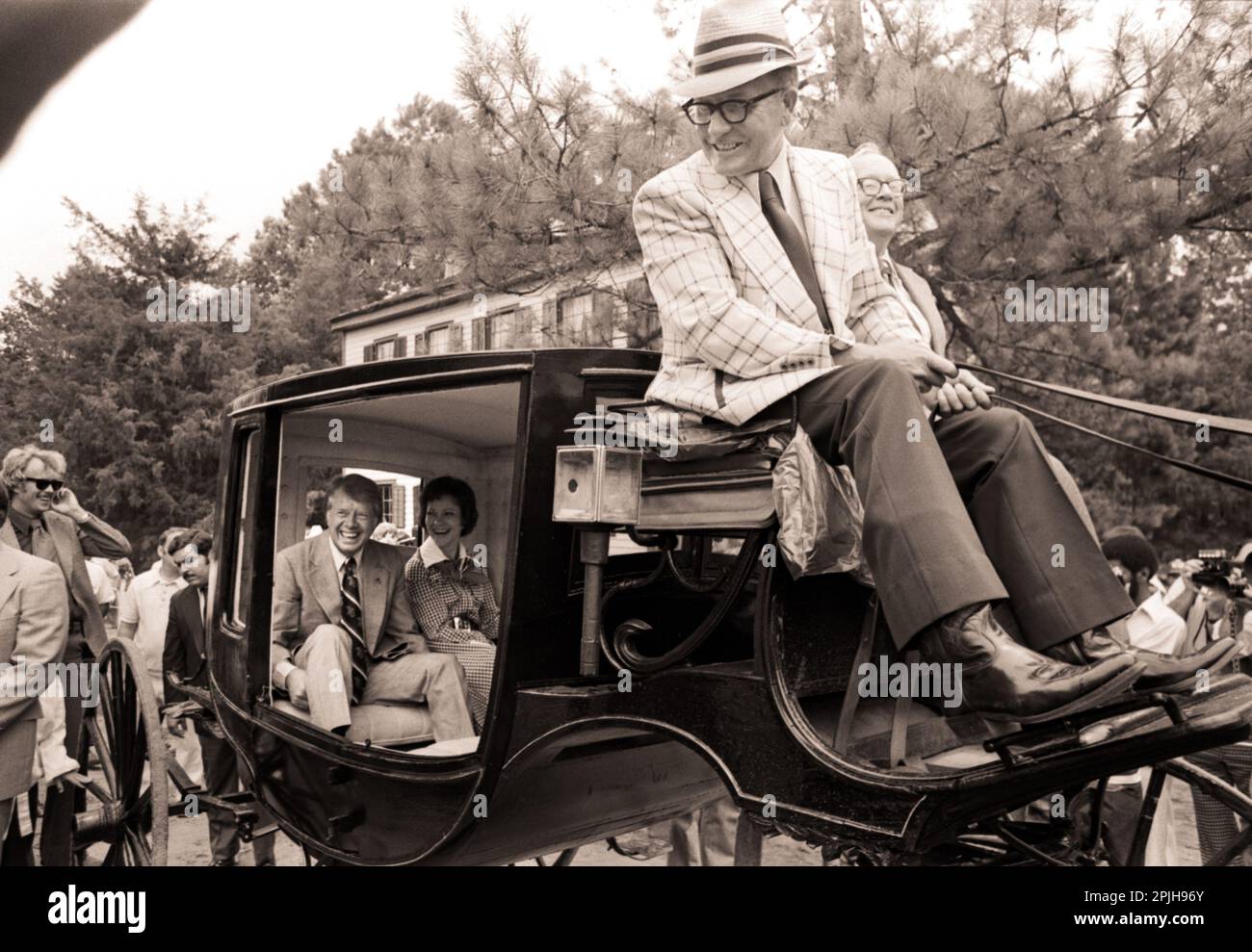 On the occasion of the US Bicentennial on July 4, 1976, candidate Jimmy Carter; his wife, Rosalynn; and daughter, Amy, ridein an 1850s carriage in Westville, Georgia, before speaking in front of a crowd of well-wishers. Stock Photo
