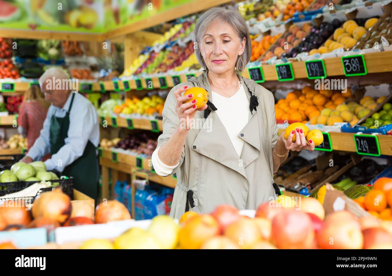Mature woman selecting fruits in supermarket Stock Photo - Alamy