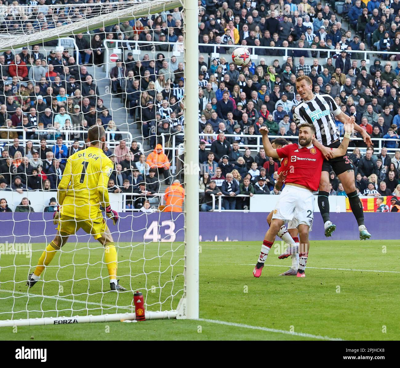 2nd April 2023; St James' Park, Newcastle, England: Premier League Football, Newcastle United versus Manchester United; Newcastle United's Dan Burn heads for goal under pressure from Manchester United's Luke Shaw but it goes wide with David De Gea watching Stock Photo