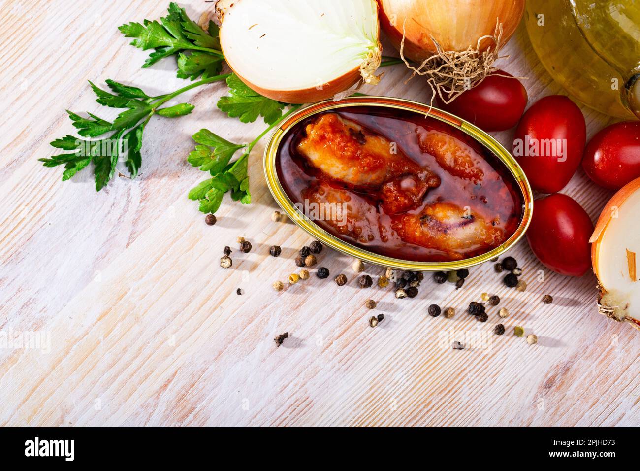 Stuffed squid in tomato sauce on background with greens, tomatoes Stock Photo