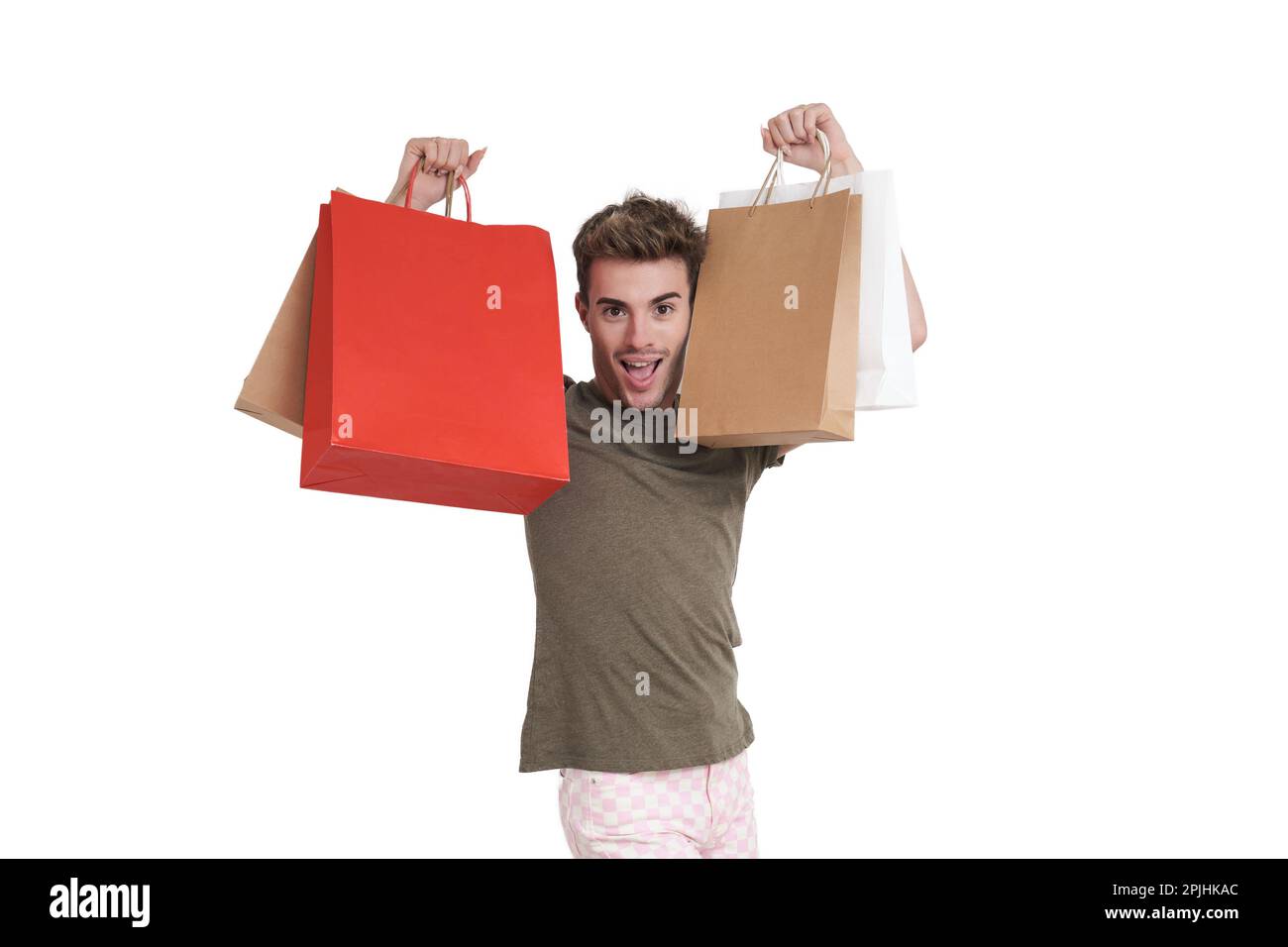 Young caucasian man super happy holding shopping bags, isolated. Stock Photo