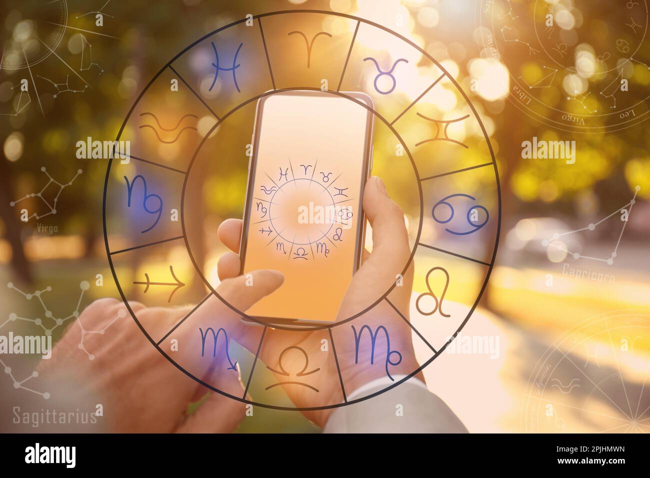Man with smartphone reading daily horoscope outdoors, closeup Stock Photo