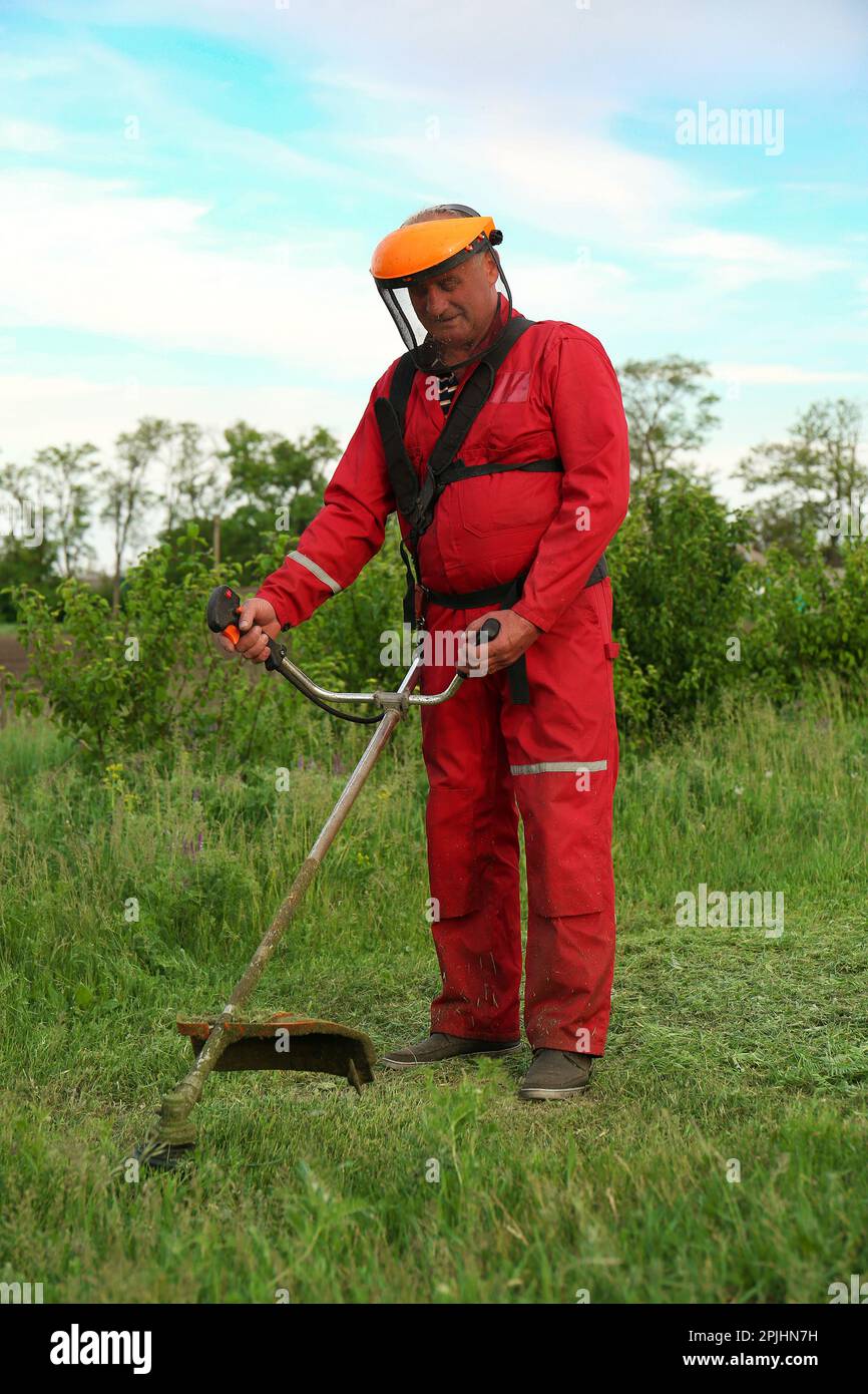 Worker cutting grass with string trimmer outdoors Stock Photo Alamy
