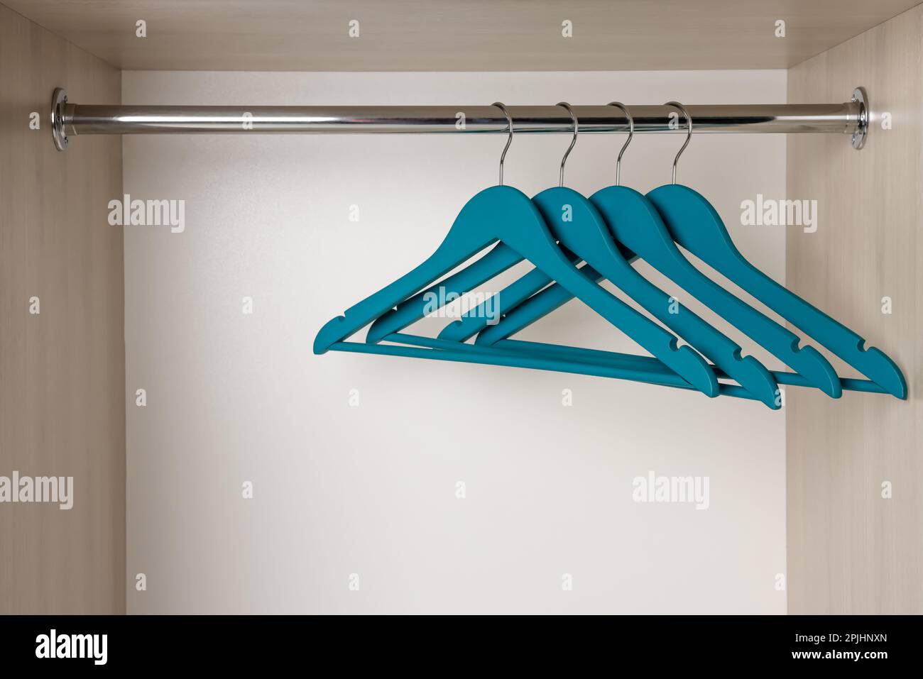 Set of blue clothes hangers on wardrobe rail Stock Photo Alamy
