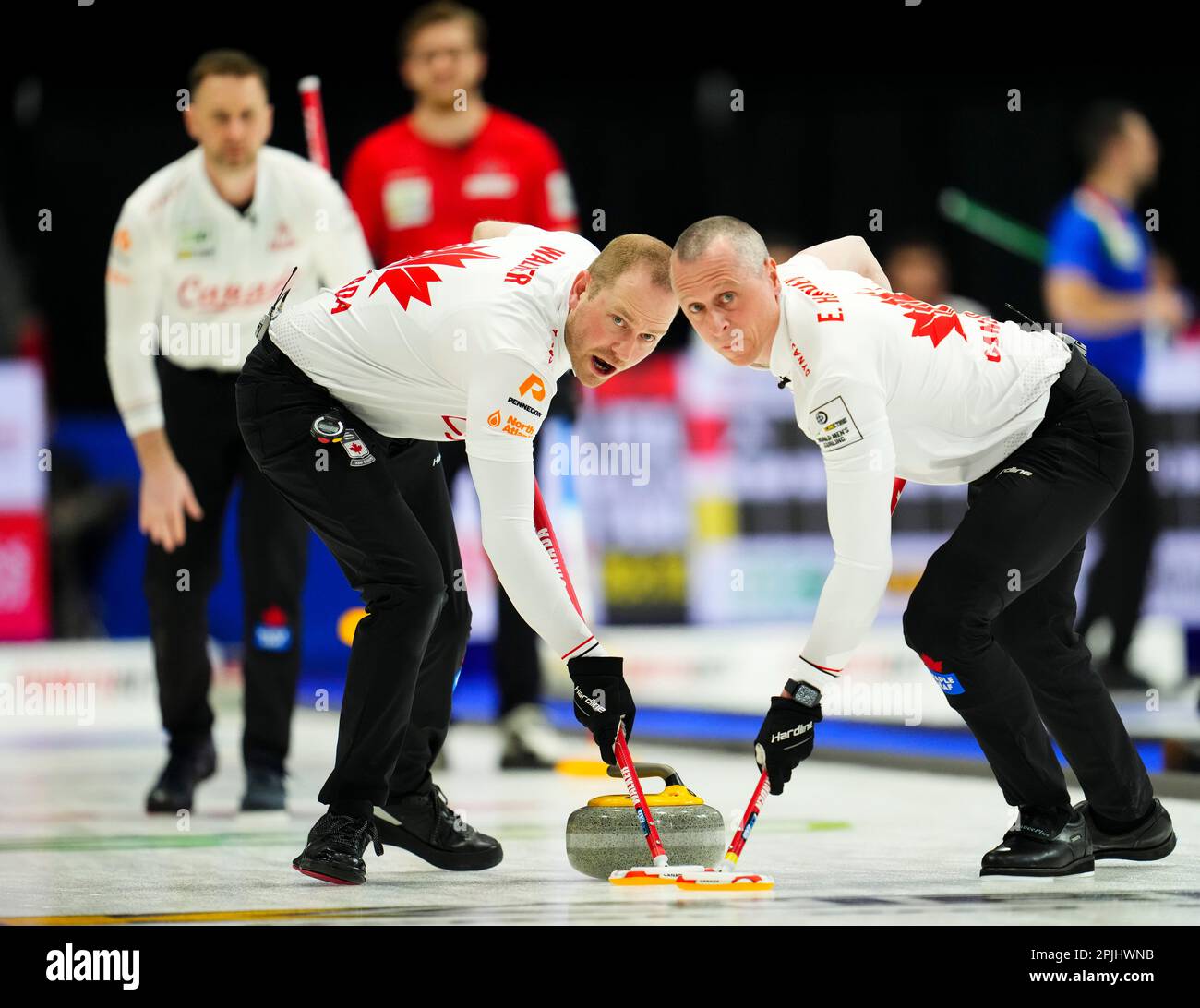 Canadian lead Geoff Walker sweeps with teammate second EJ Harnden as they take on Norway at the Mens World Curling Championship in Ottawa, Ontario, Sunday, April 2, 2023