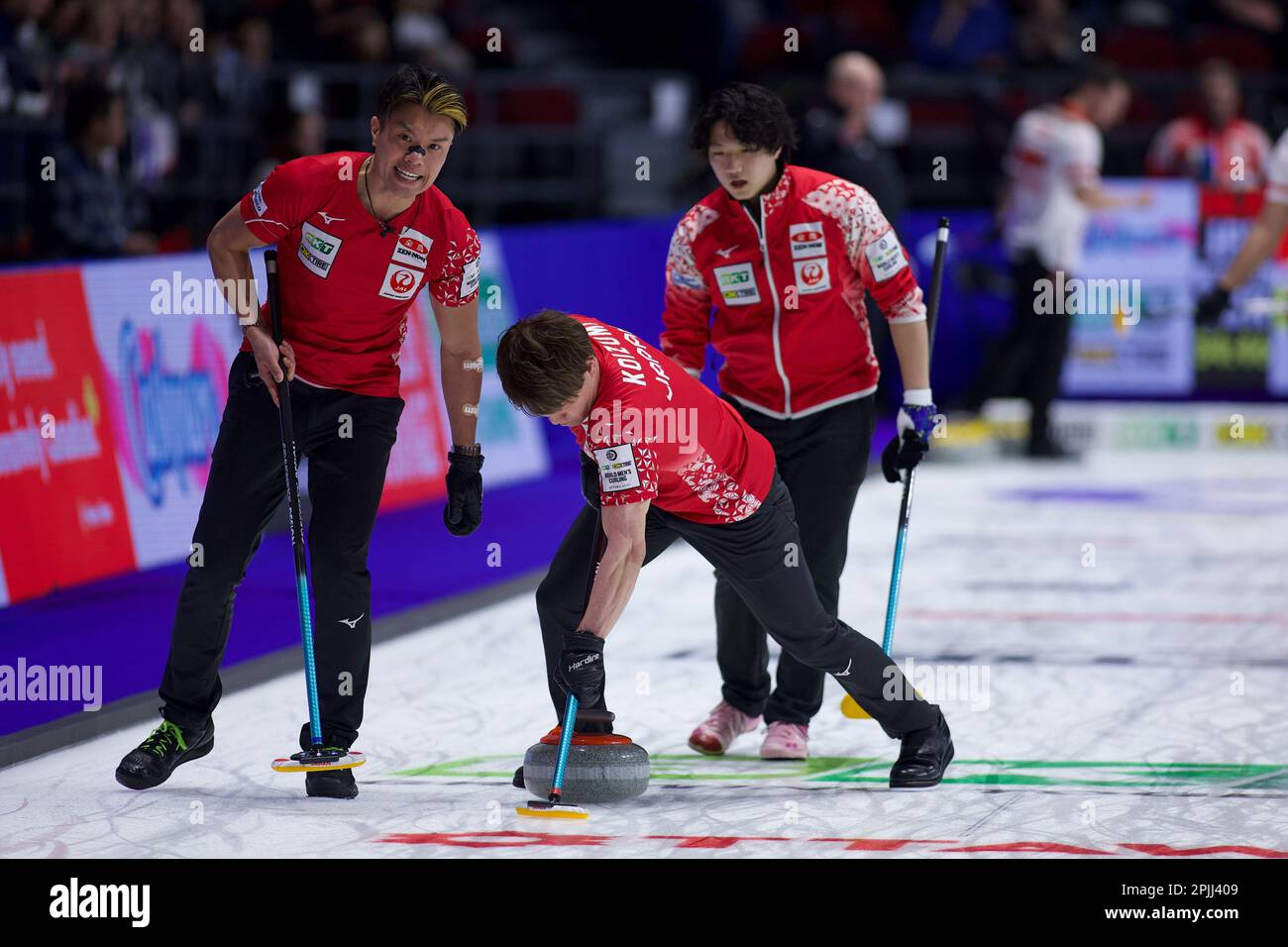 Tsuyoshi Yamaguchi (L) and Satoshi Koizumi (R) sweep a stone while
