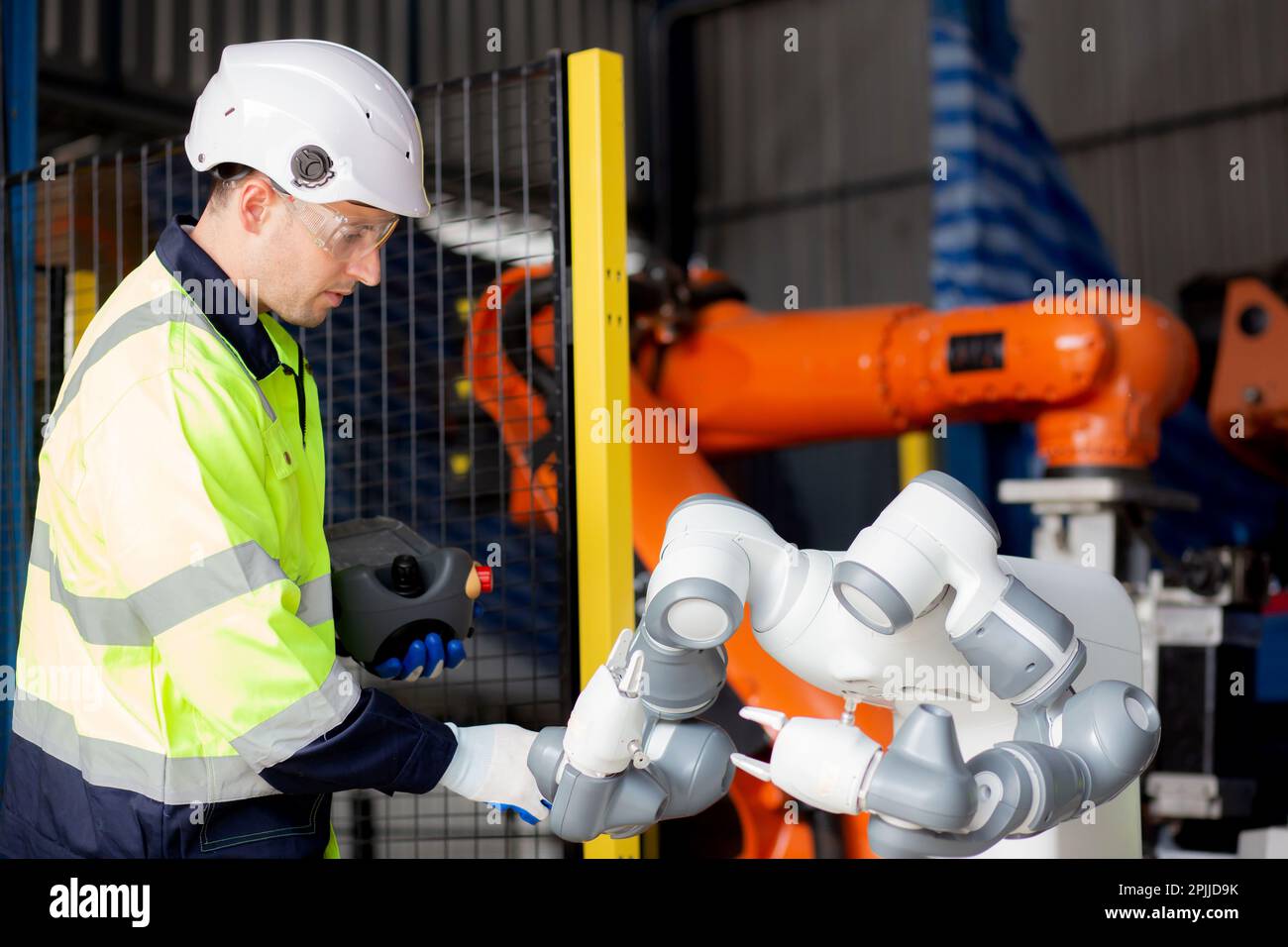 Young engineer man checking and maintenance machine robot arms ...