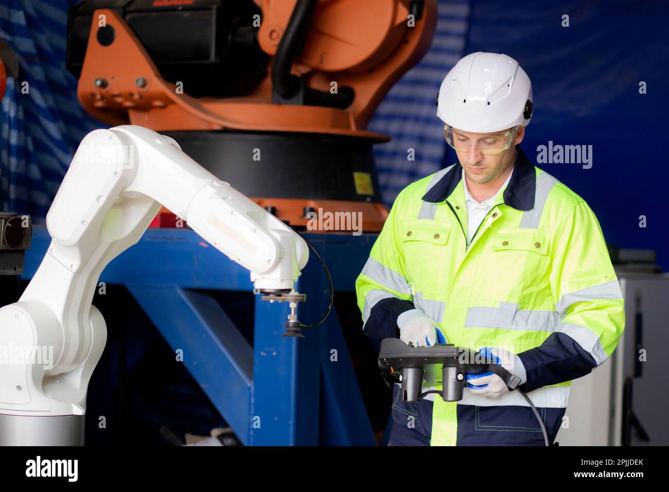 Young engineer man checking and maintenance machine robot arms ...