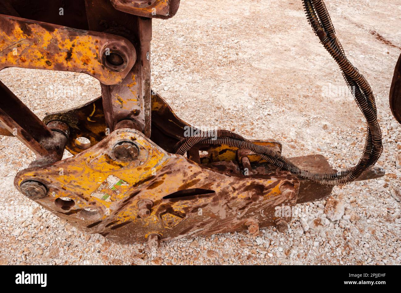 A jackhammer attached to a backhoe arm is left to rest on a marly roadway Stock Photo Alamy