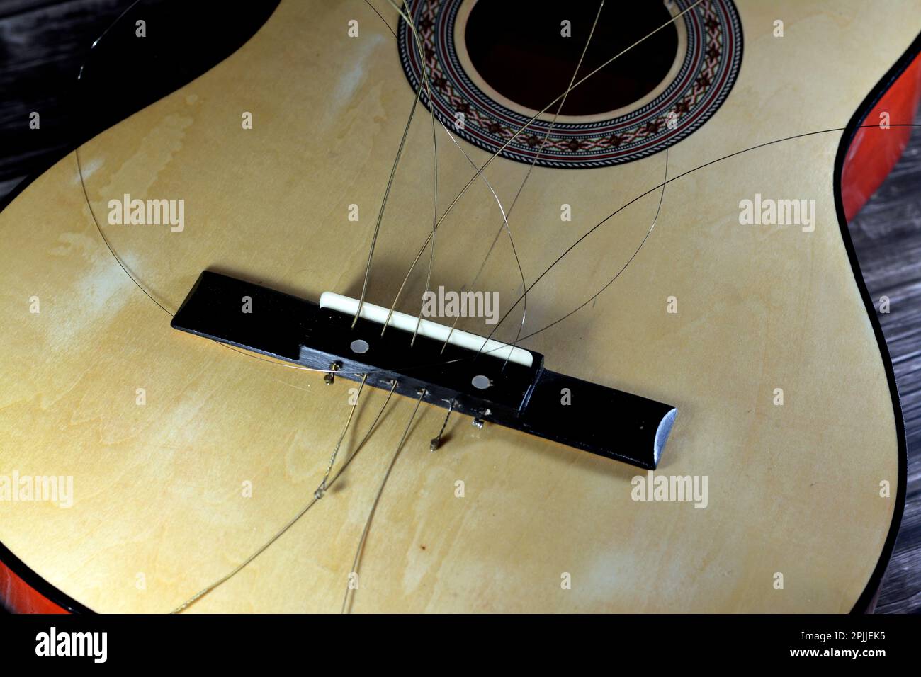 A broken wooden old classic guitar with damaged strings chords