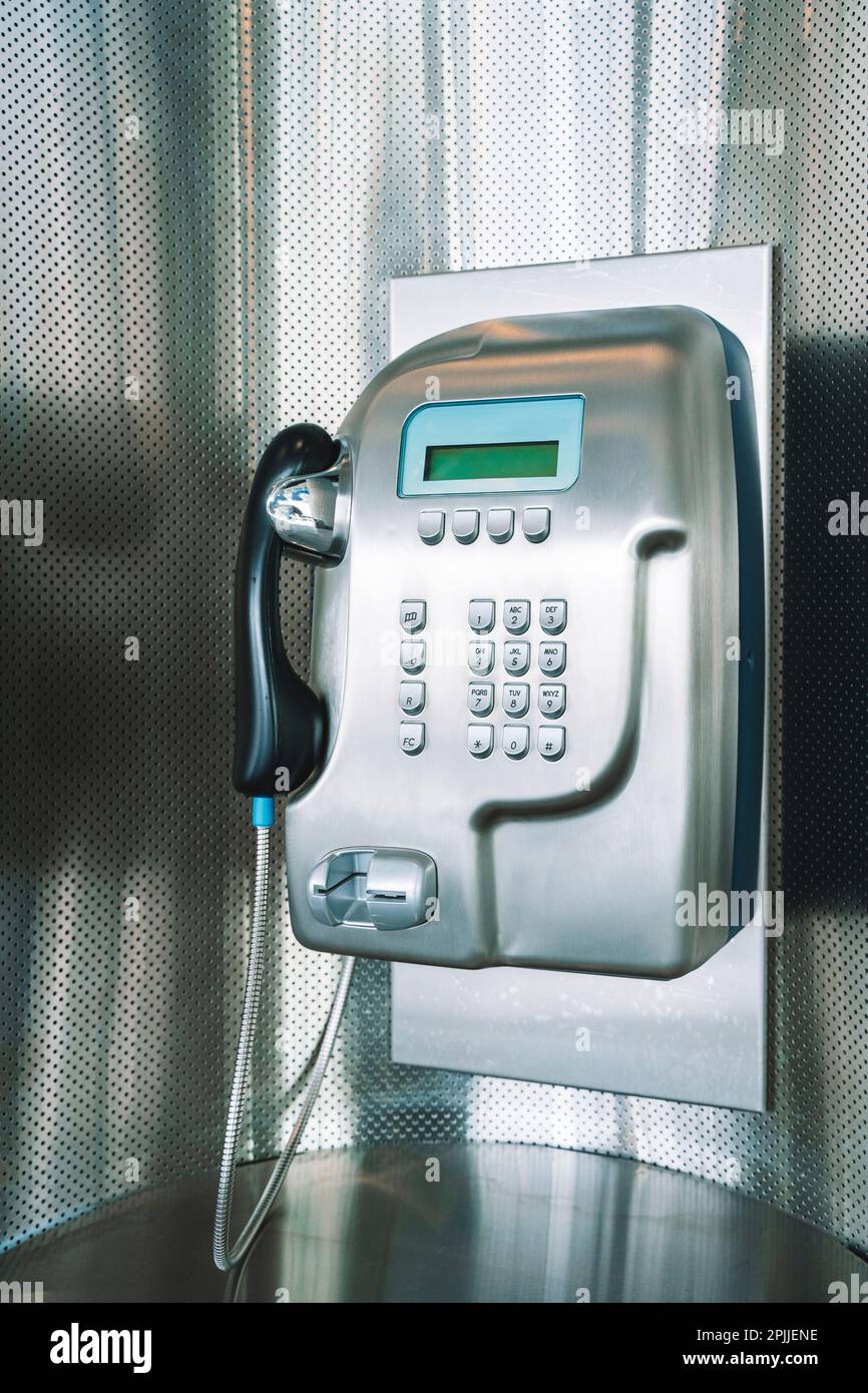 Payphone on the wall. Modern payphone for paid calls in a public place. High quality photo Stock Photo