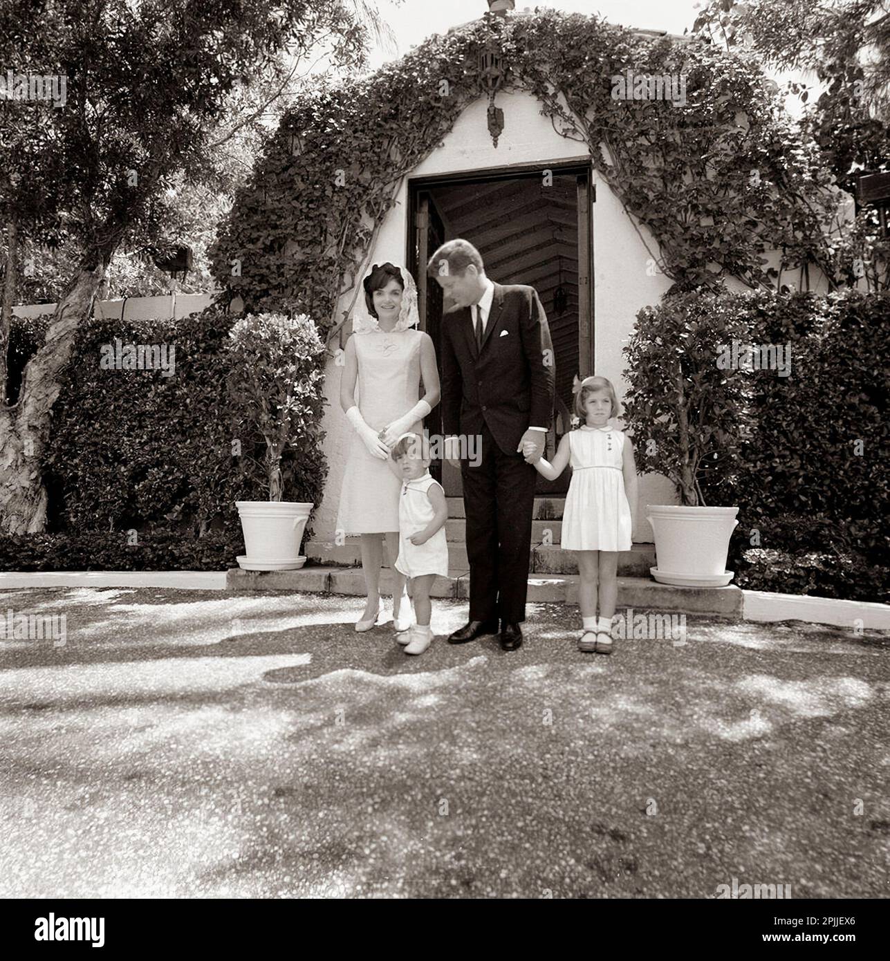 ST-C83-7-63                                            14 April 1963   The Kennedy family leaves the private chapel at the residence of Ambassador Joseph P. Kennedy, Sr. in Palm Beach, Florida following Easter Sunday service. (L-R) First Lady Jacqueline Kennedy; John F. Kennedy, Jr.; President John F. Kennedy; Caroline Kennedy.   Please credit “Cecil Stoughton. White House Photographs. John F. Kennedy Presidential Library and Museum, Boston” Stock Photo