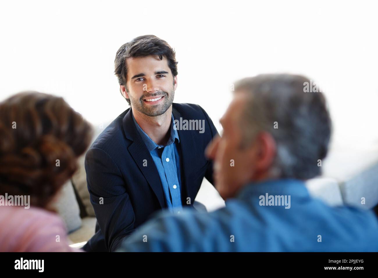 Sharing his great advice with them. A young consultant giving advice to a mature couple. Stock Photo