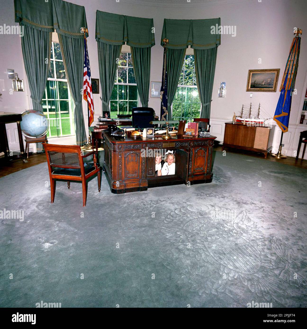 ST-C221-1-63   22 JUN 1963 President John F. Kennedy's daughter Caroline and a friend  under the President's desk in the Oval Office at the White House.    Please credit 'Cecil Stoughton (Harold Sellers). White House Photographs. John F. Kennedy Presidential Library and Museum, Boston' Stock Photo