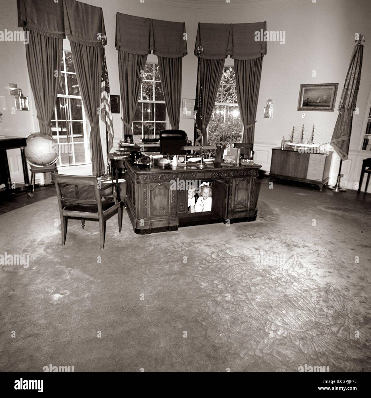ST-C221-1-63   22 JUN 1963 President John F. Kennedy's daughter Caroline and a friend  under the President's desk in the Oval Office at the White House.    Please credit 'Cecil Stoughton (Harold Sellers). White House Photographs. John F. Kennedy Presidential Library and Museum, Boston' Stock Photo
