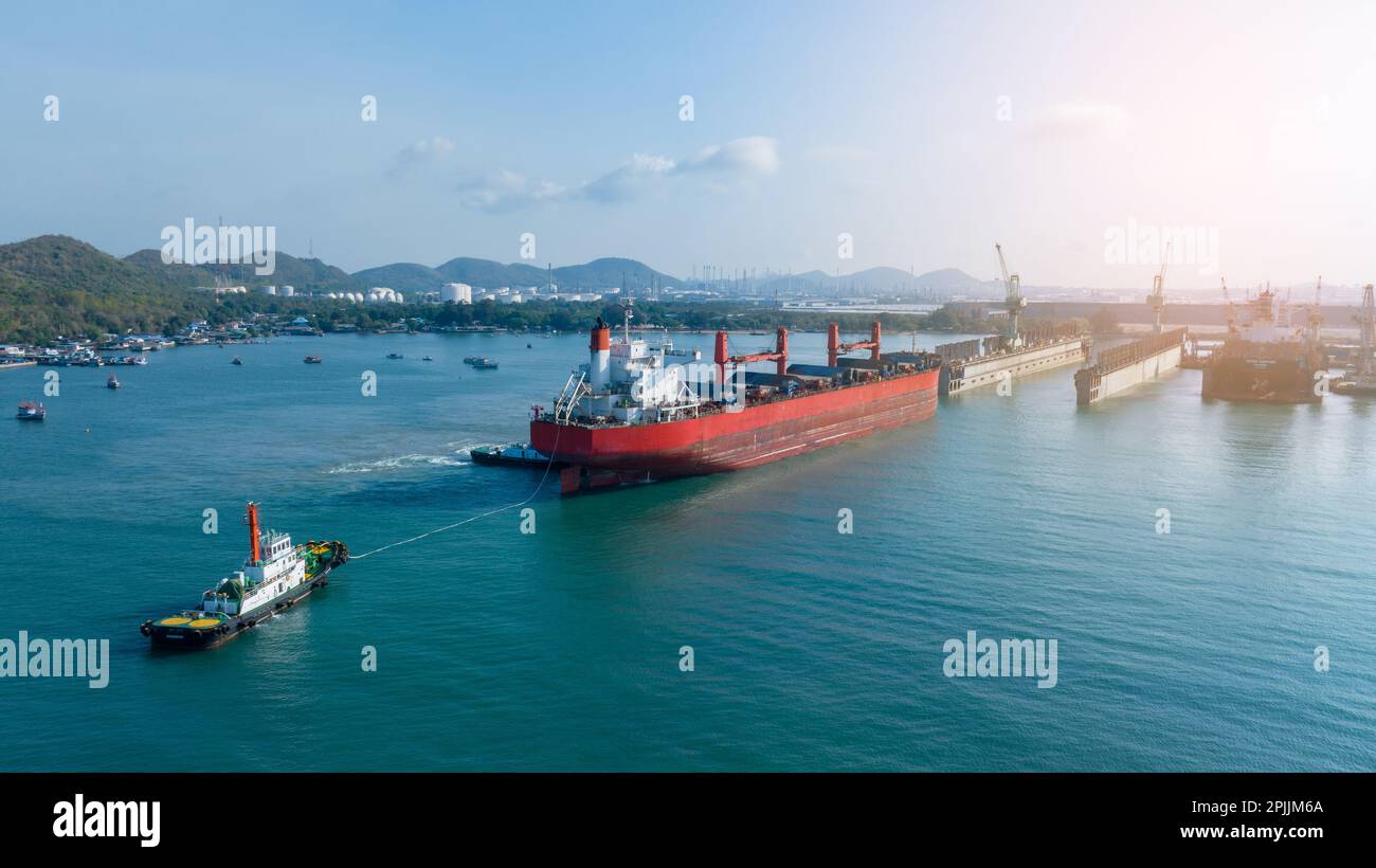 Tug boat Draging cargo container ship to dry dock concept maintenance ...