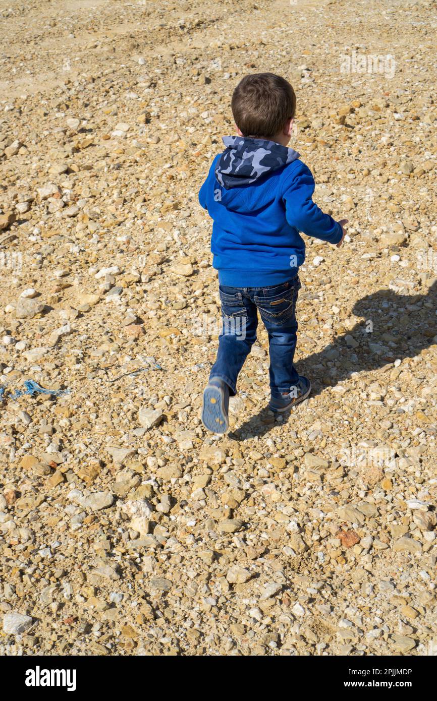 Little boy running away outdoors Stock Photo