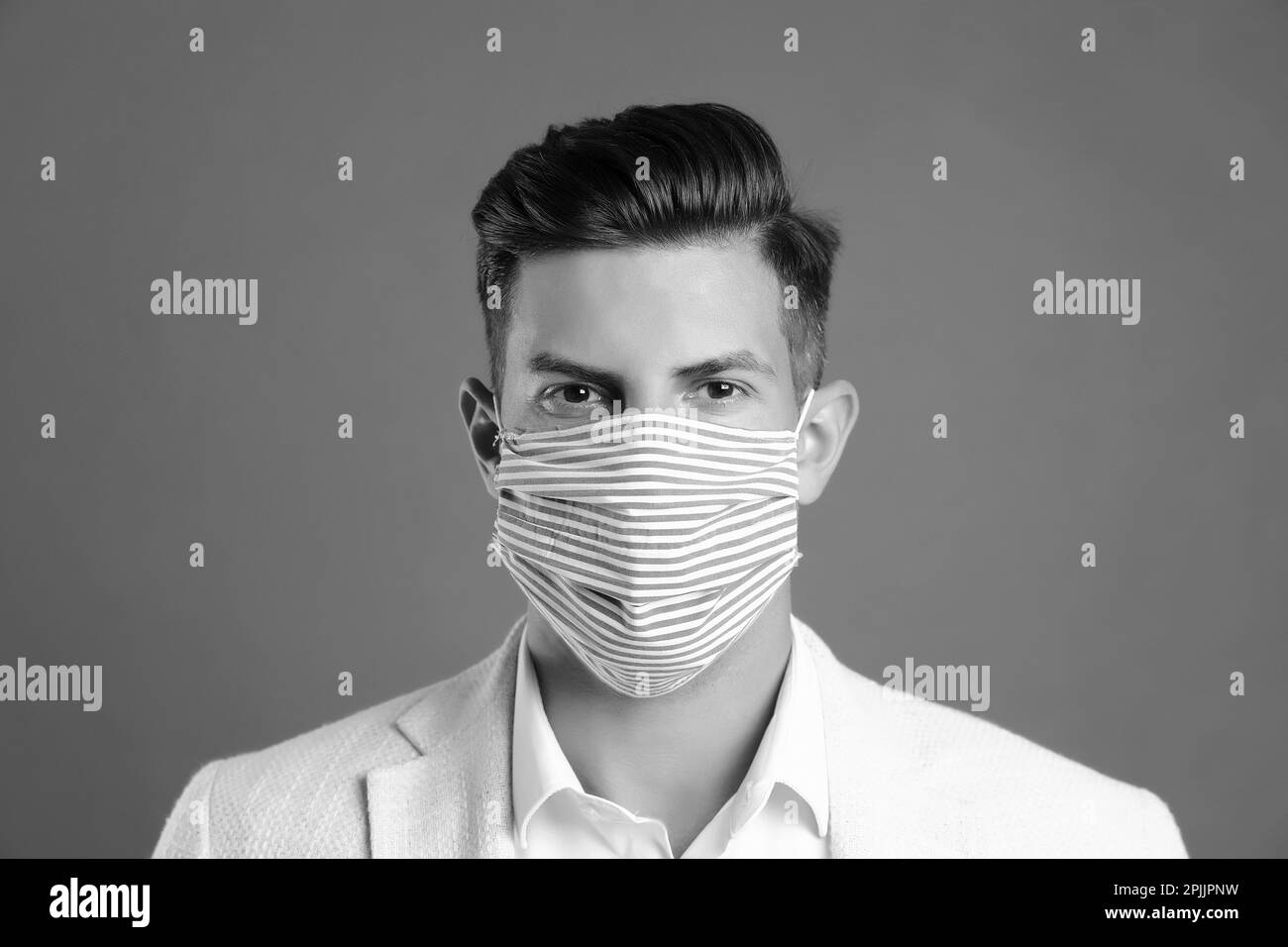 Man wearing medical face mask on grey background. Black and white ...