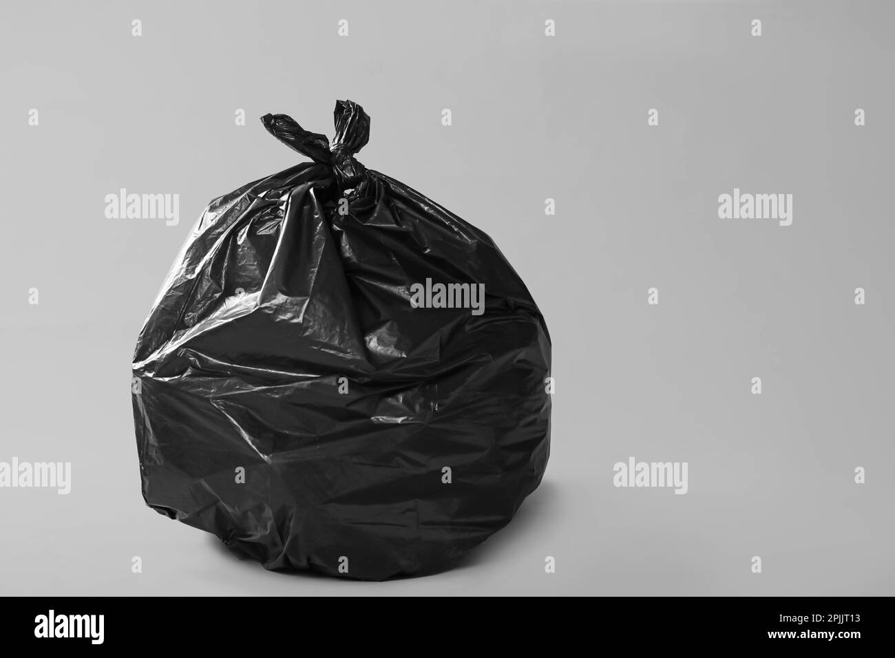 Trash bag full of garbage on grey background. Space for text Stock ...