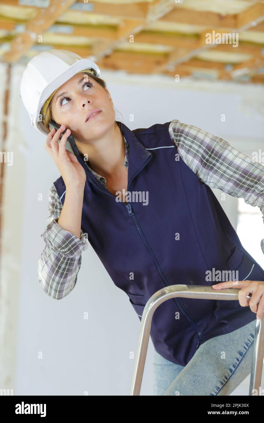 female builder using a smartphone Stock Photo