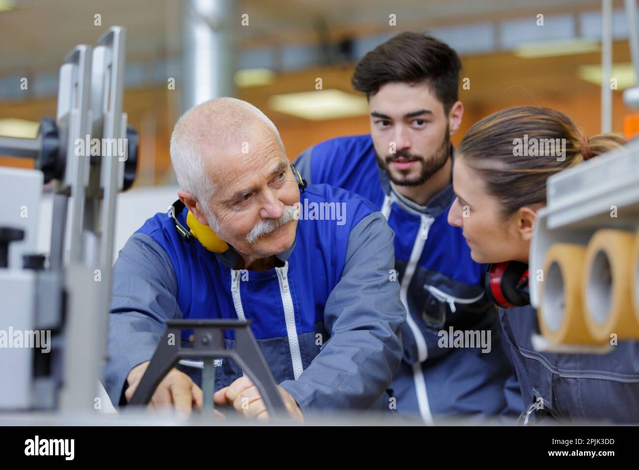 engineer and apprentice working on machine in factory Stock Photo