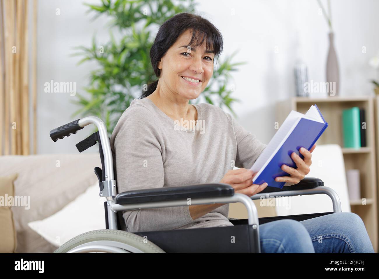 young disabled woman in wheelchair with book Stock Photo - Alamy