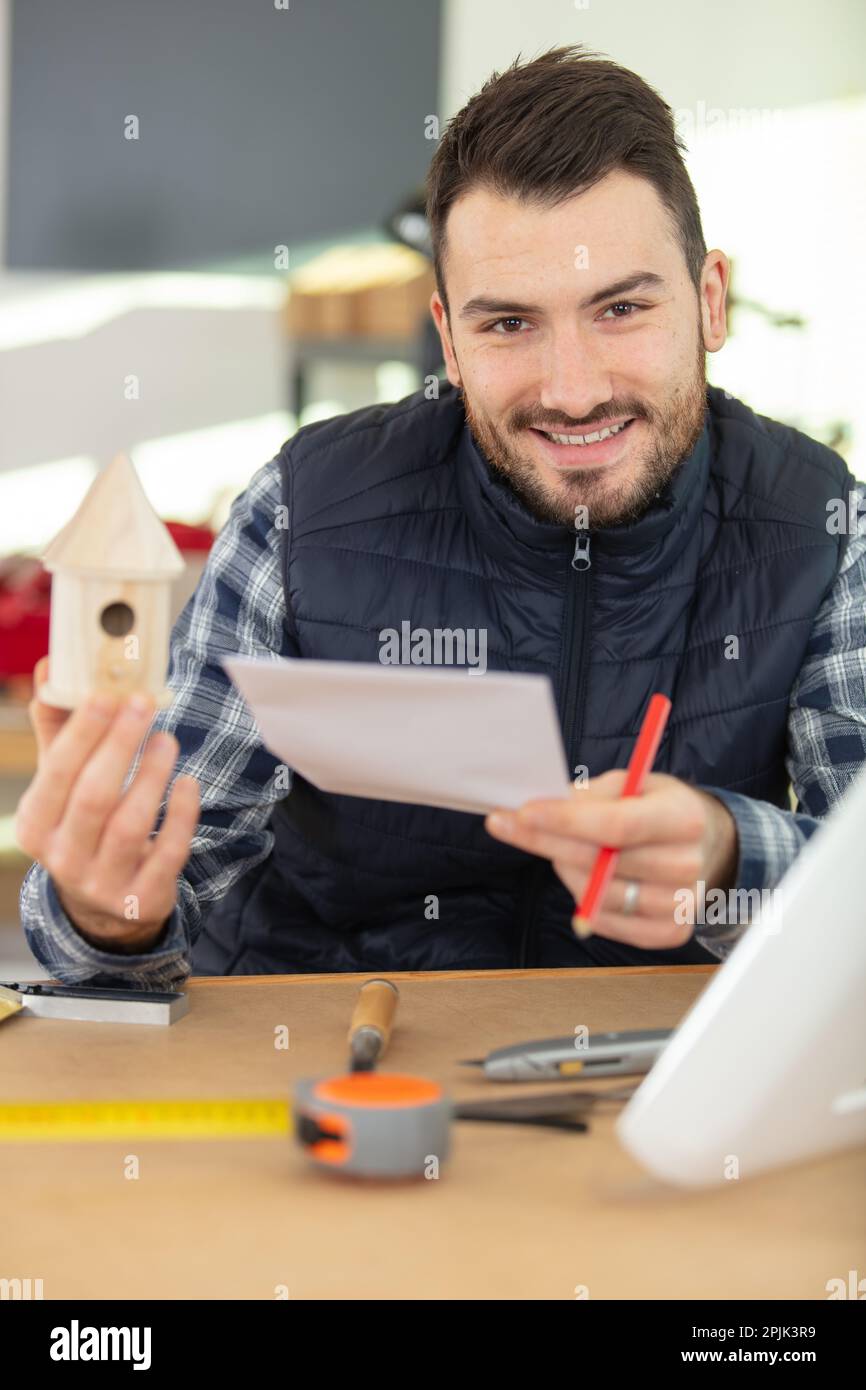carpenter making the birdhouse smiling Stock Photo Alamy