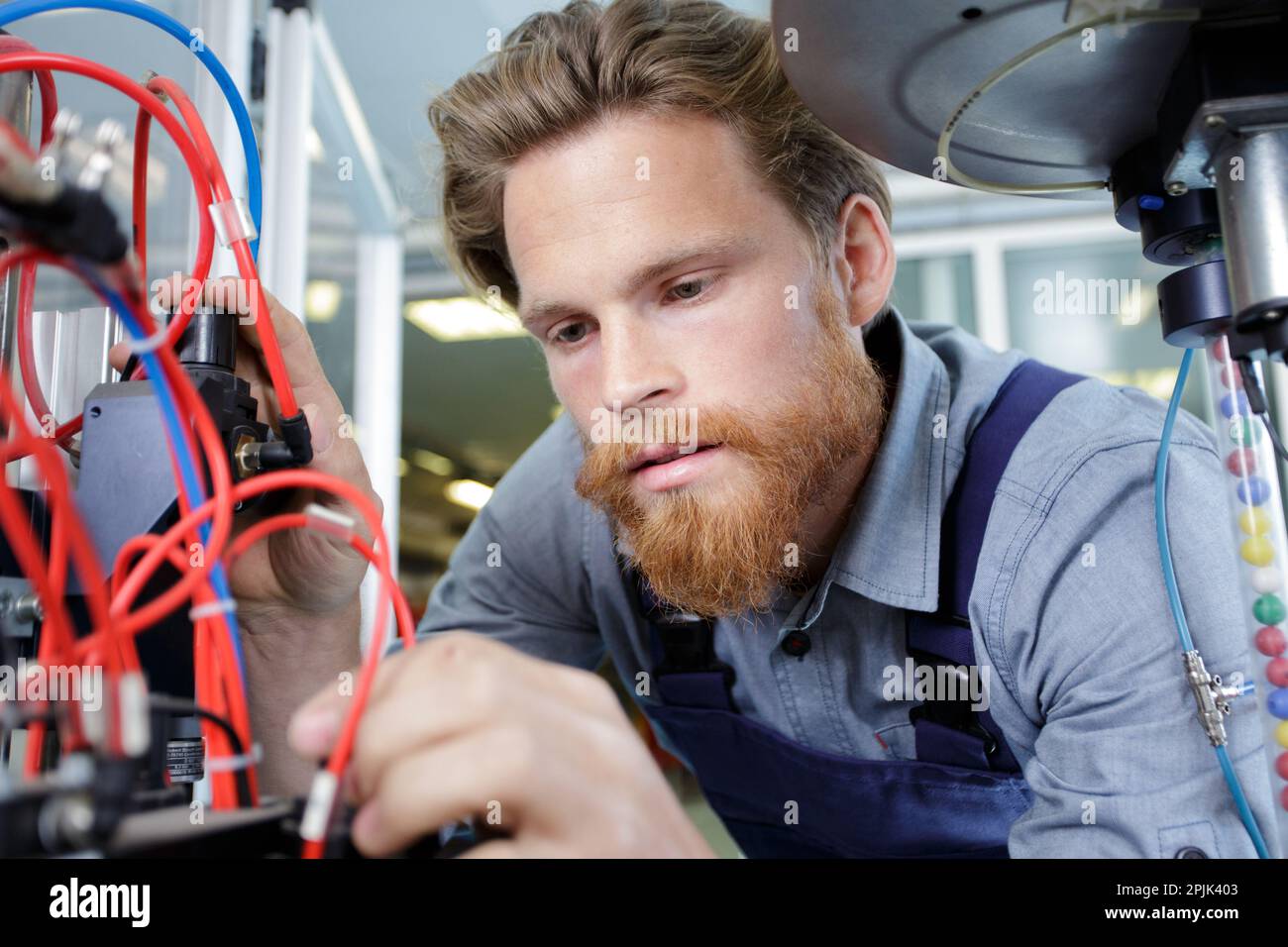 young mechanical engineering operates a machine Stock Photo