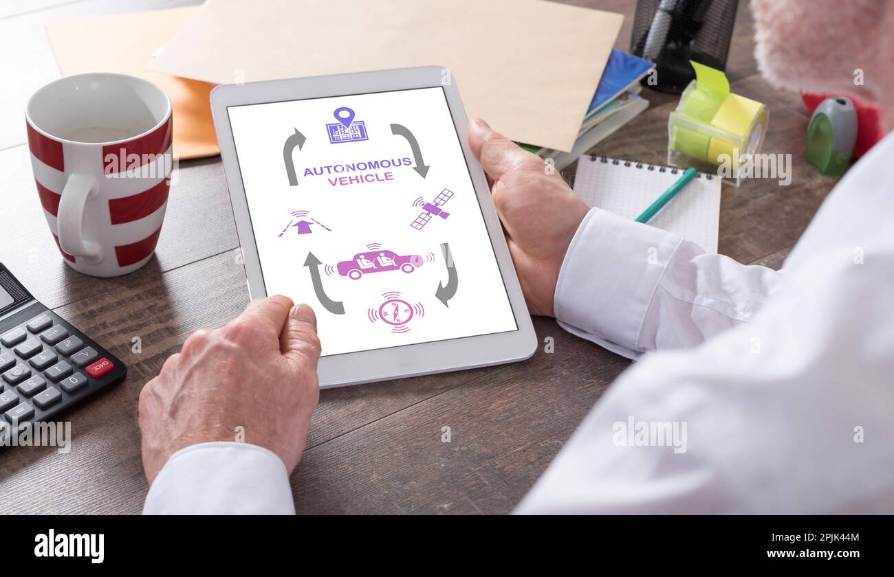 Autonomous vehicle concept shown on a tablet held by a man Stock Photo