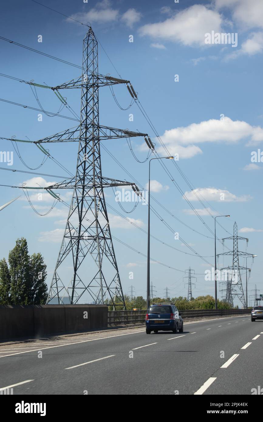 Tall electricity pylons and cables in an urban environment by the side
