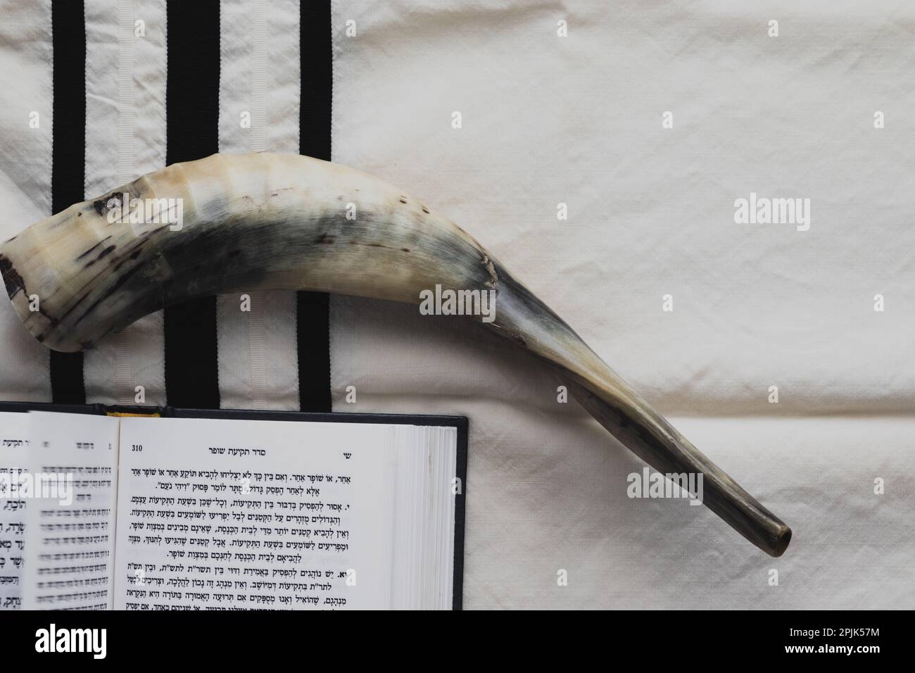 07-07-2022. jerusalem-israel. A prayer book for the Jewish Rosh Hashanah holiday - open and placed on a tallit with black stripes, next to a shofar ma Stock Photo