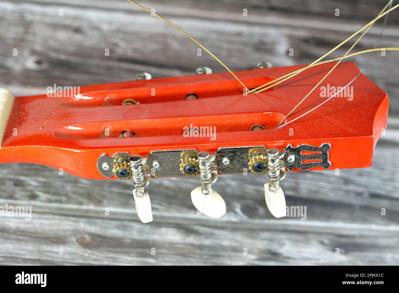 A broken wooden old classic guitar with damaged strings chords