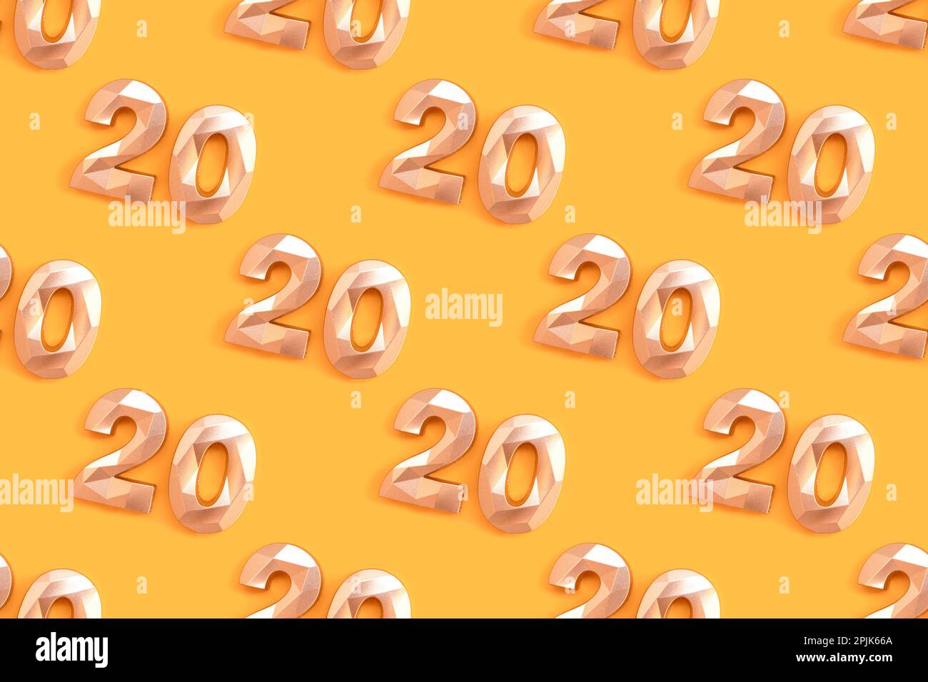 Pattern made of golden number twenty on a yellow background. Stock Photo
