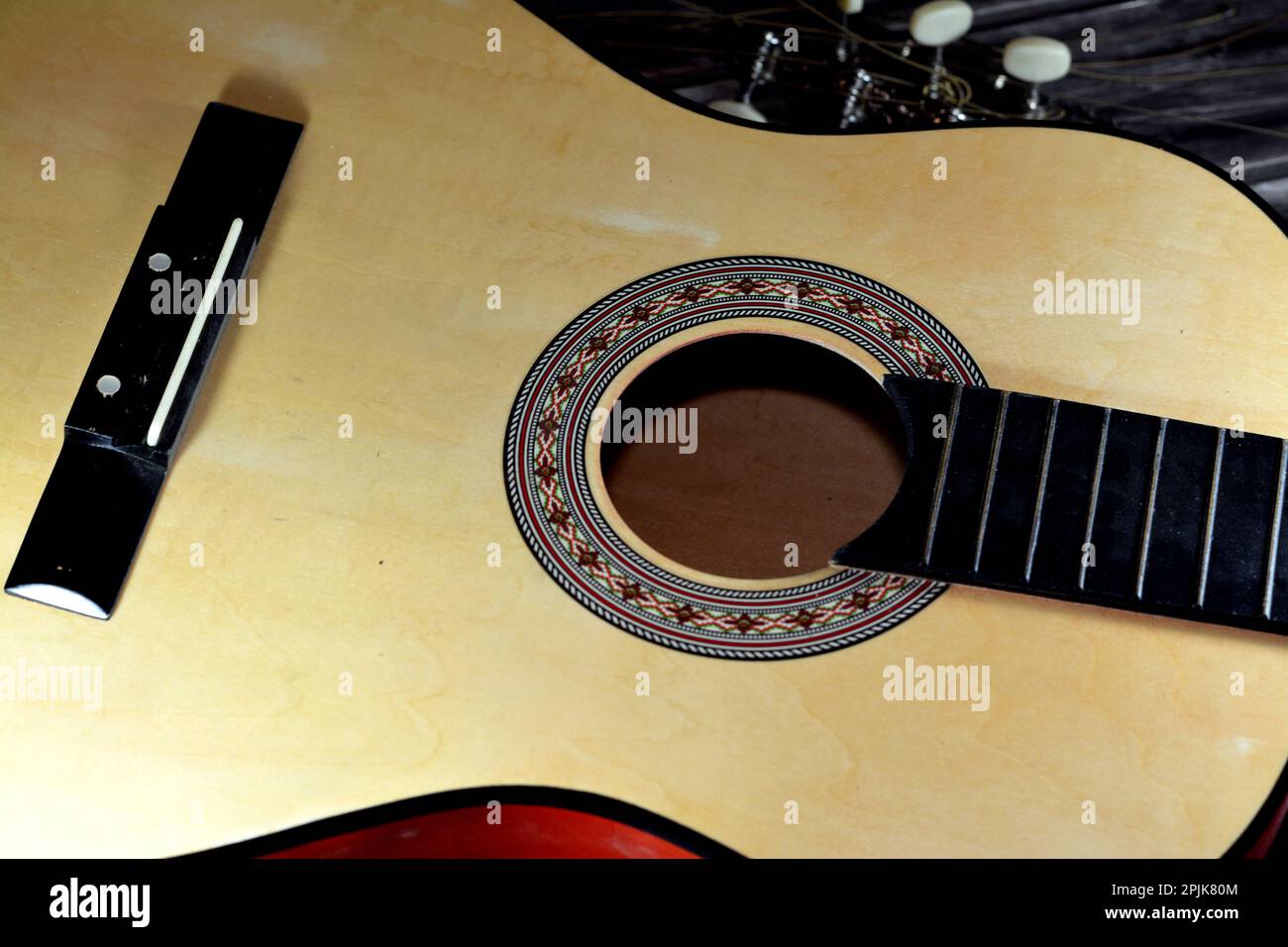 A broken wooden old classic guitar with damaged strings chords