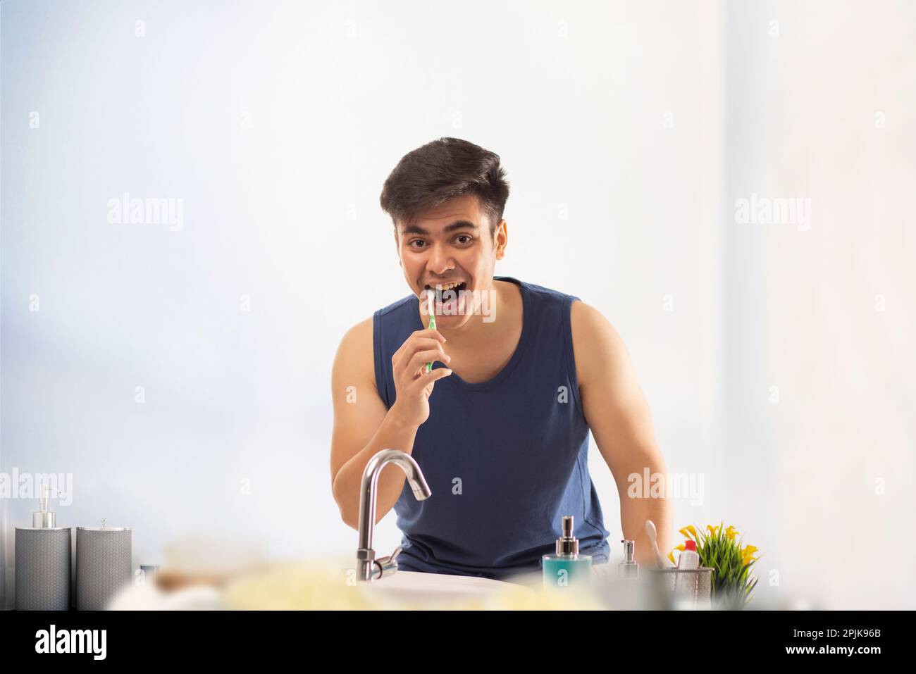 Young man brushing his teeth in bathroom at home Stock Photo