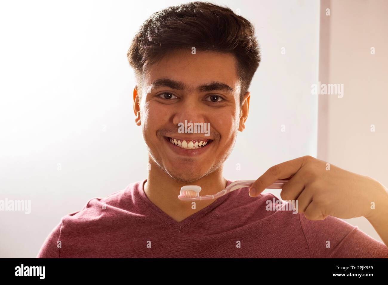 Close-up portrait of a smiling man brushing his teeth Stock Photo