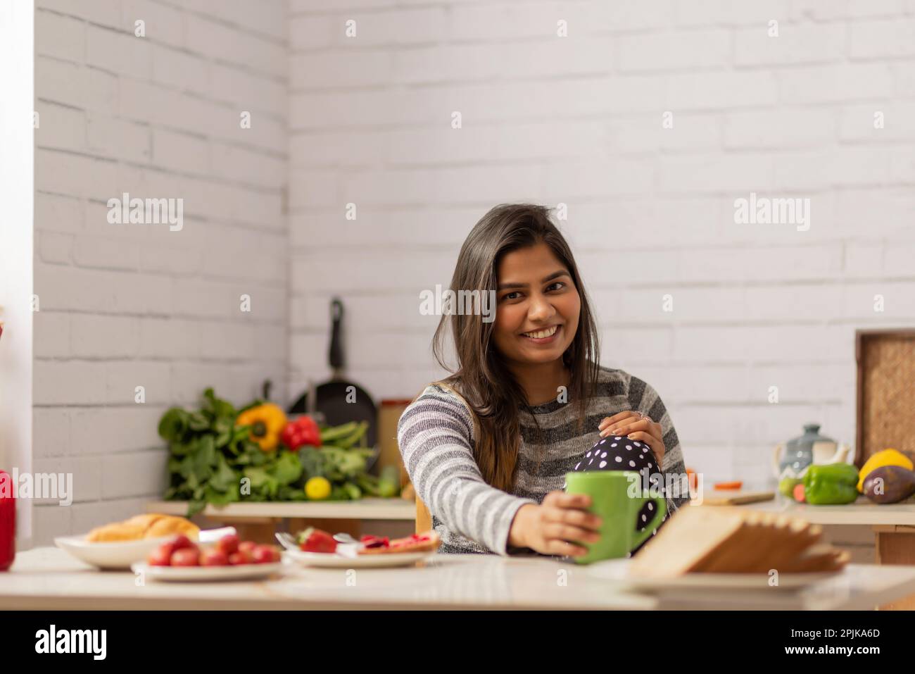 Portrait woman drinking coffee during breakfast in kitchen Stock Photo
