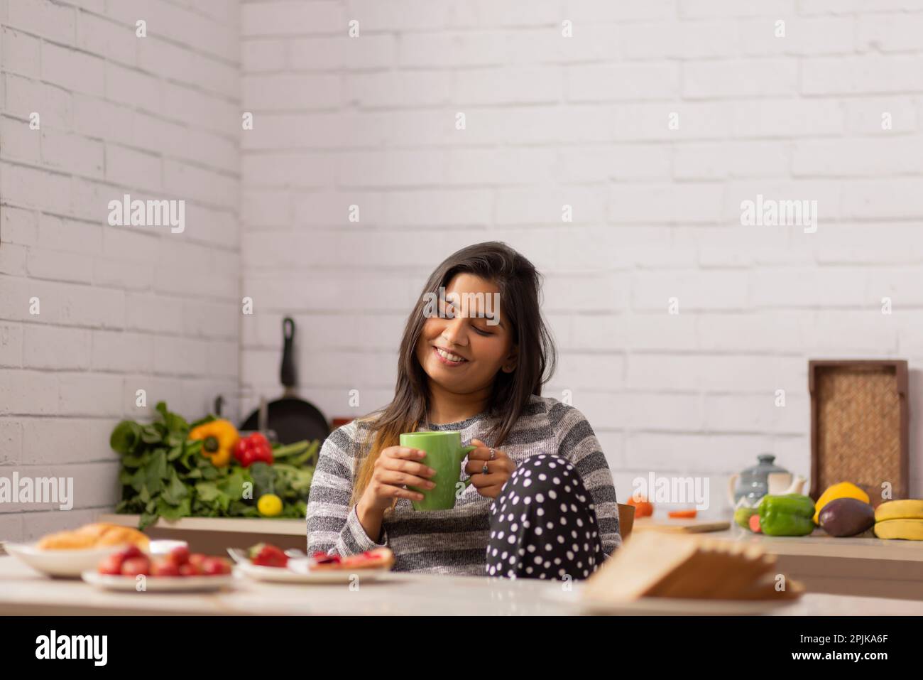 Portrait woman drinking coffee during breakfast in kitchen Stock Photo