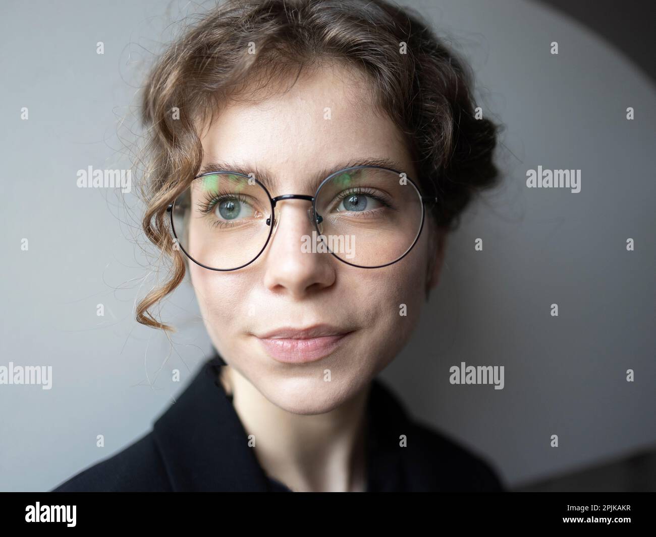 face portrait of a teenage girl 18 -19 years old, schoolgirl, college student. cute young smart woman in glasses, thinks, looks away. Real people, eve Stock Photo