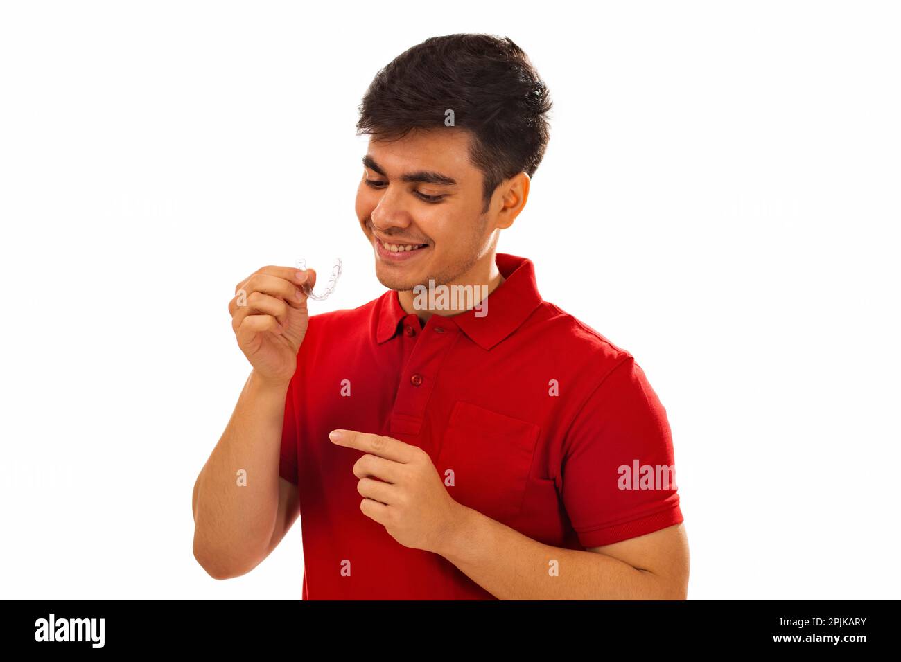 Smiling young man holding teeth aligner against white background Stock ...