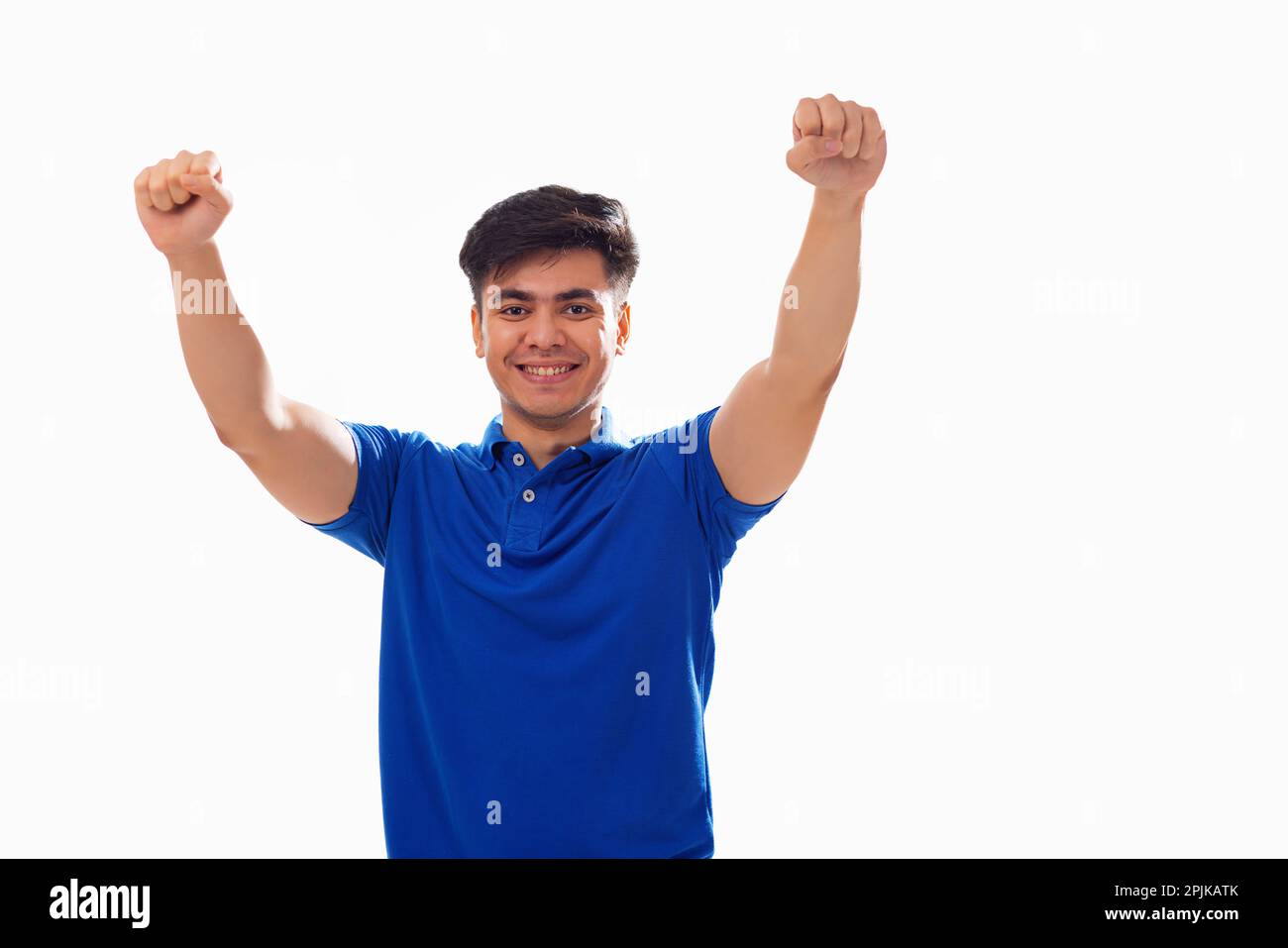 Portrait of young man cheering against white background Stock Photo