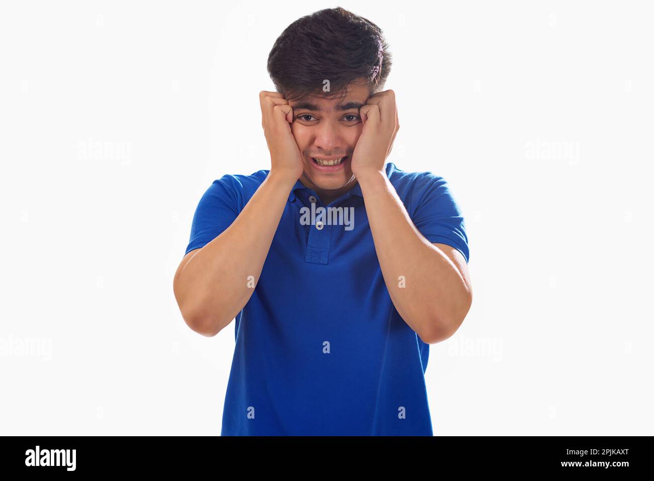 Portrait of frustrated young man against white background Stock Photo