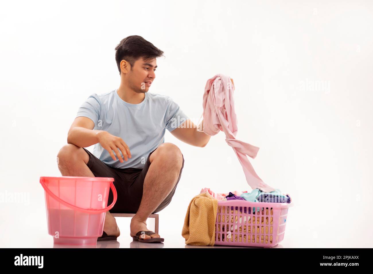Portrait of young man washing clothes by hand Stock Photo