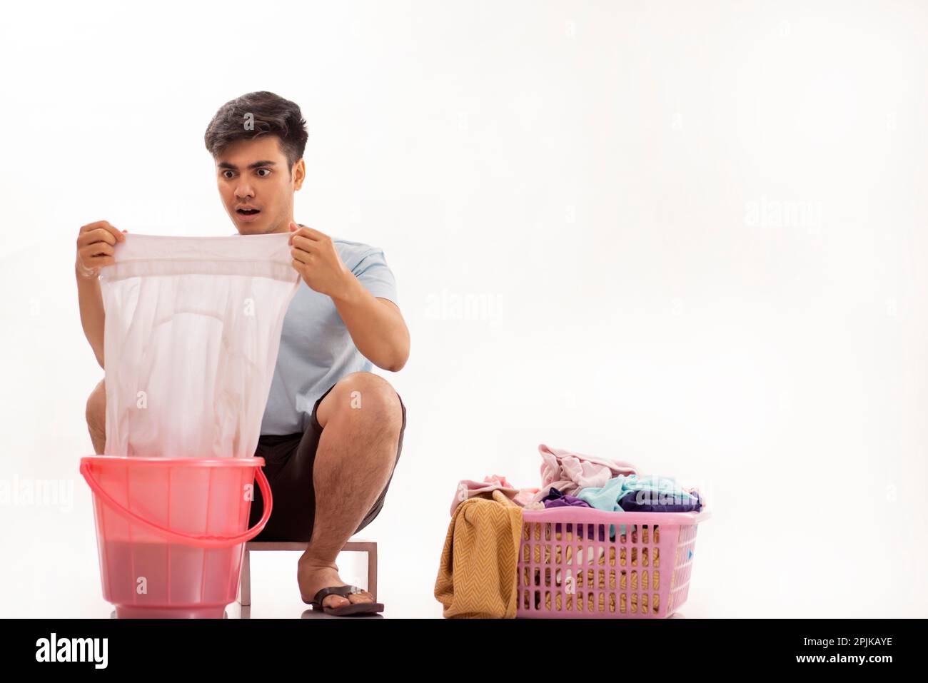 Portrait of young man washing clothes by hand Stock Photo