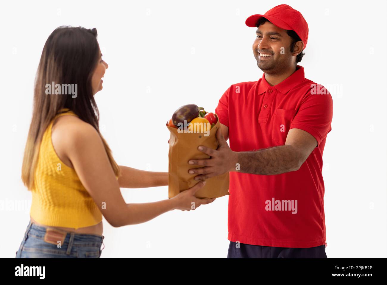 Woman taking delivery of fresh vegetable from delivery boy Stock Photo