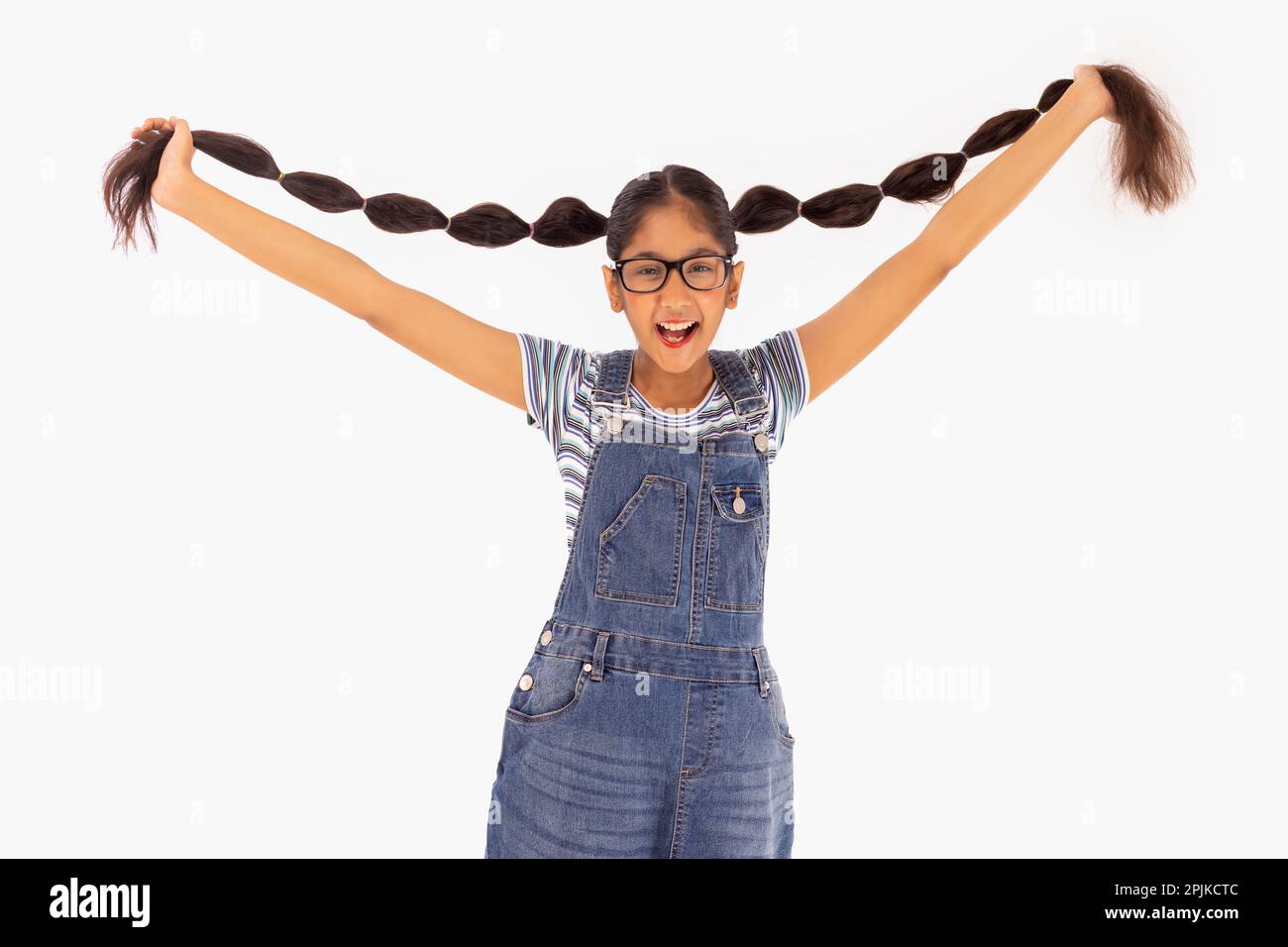 Tween girl holding her braids up against white background Stock Photo