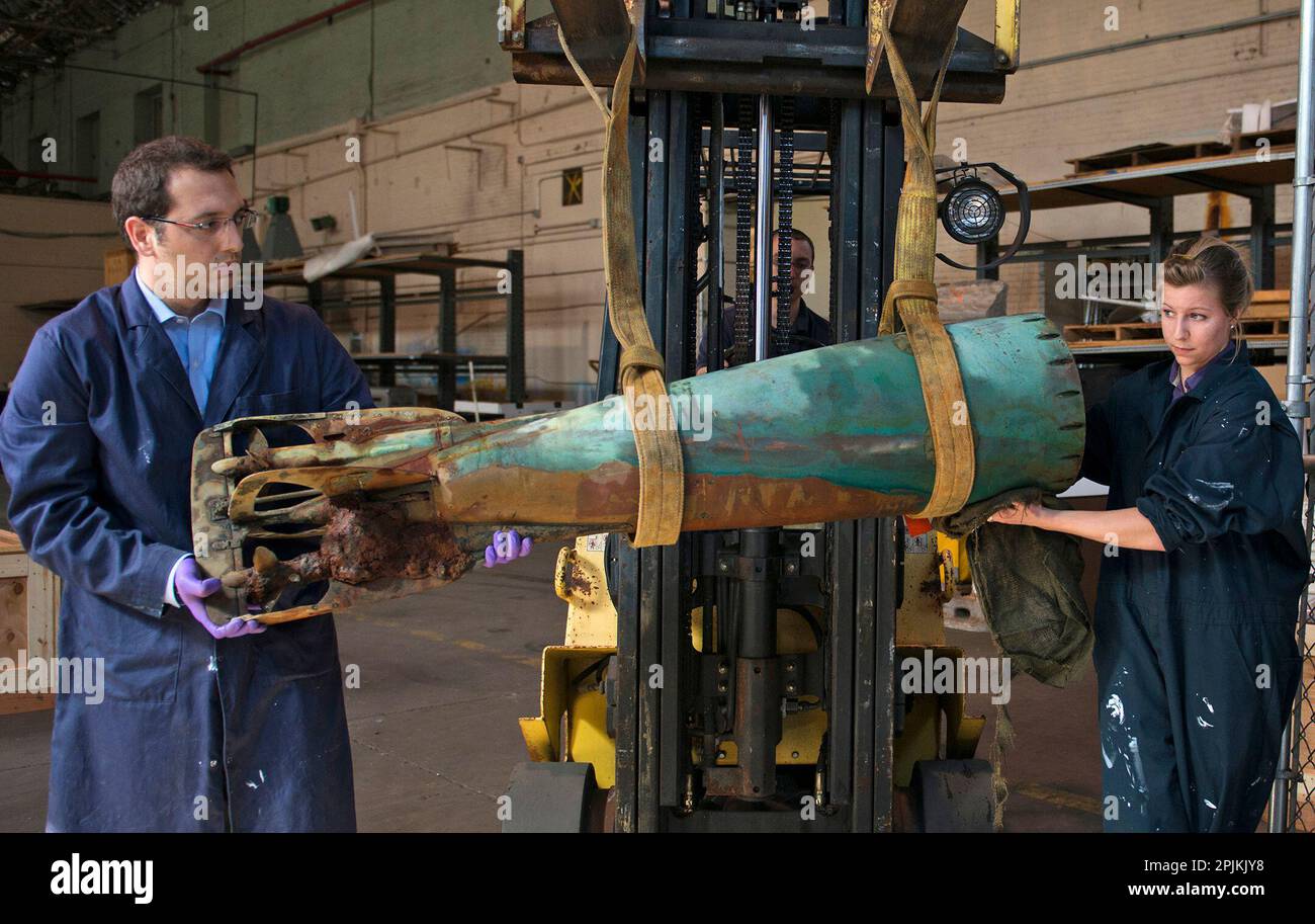 WASHINGTON, May 30, 2013: Dr. Alexis Catsambis, left, cultural resource manager, and Blair Atcheson, historical preservation coordinator, both from the Naval History and Heritage Command at the Washington Navy Yard, move a late 19th century Howell torpedo. The torpedo was discovered by a team of Navy dolphins off the coast of San Diego and is scheduled to undergo months of restoration by a Navy archaeological team. Stock Photo