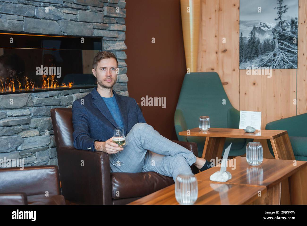 Man with wineglass sitting in chair at luxury hotel during vacation Stock Photo